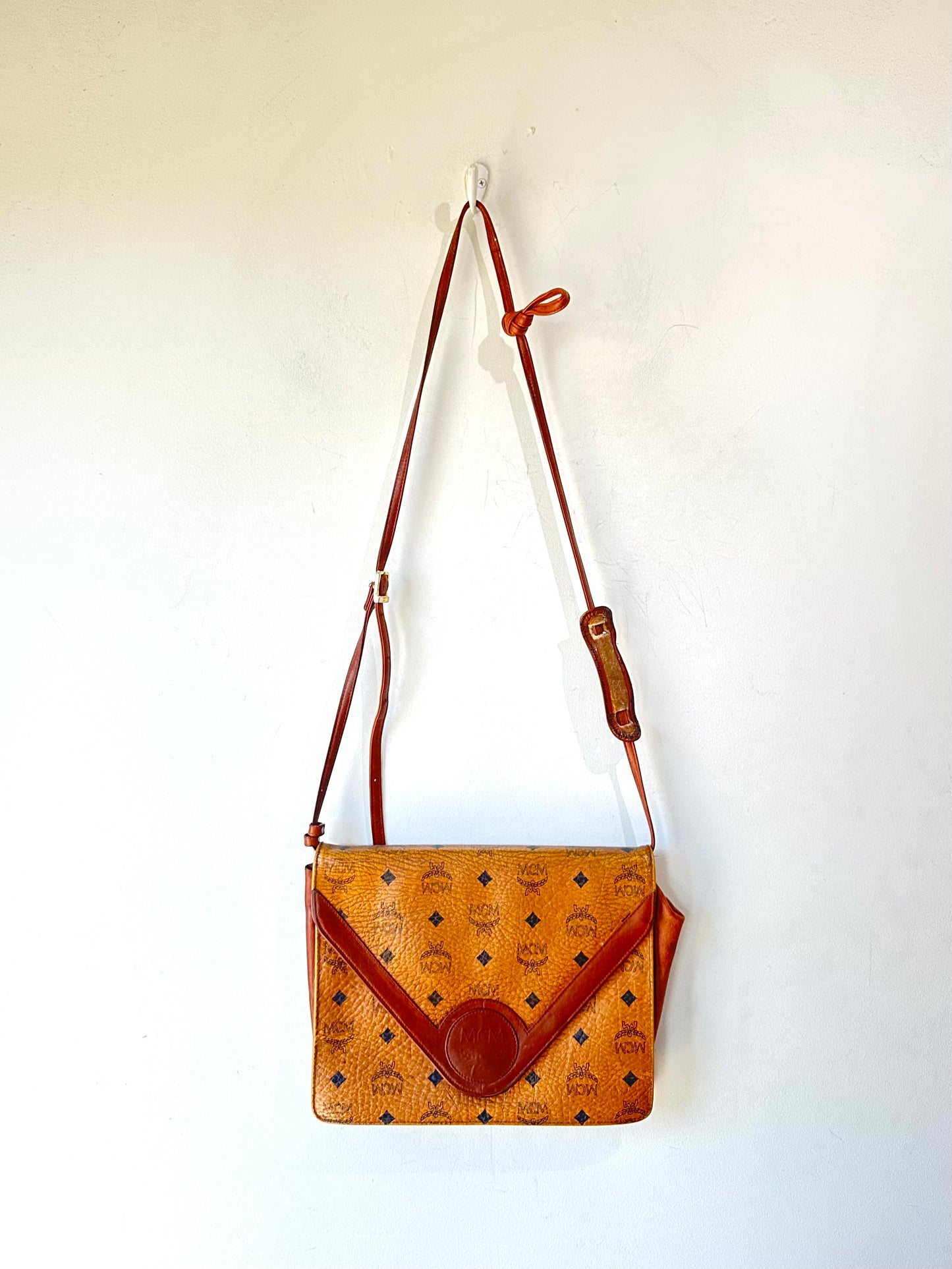 Brown leather handbag with a strap on a white background