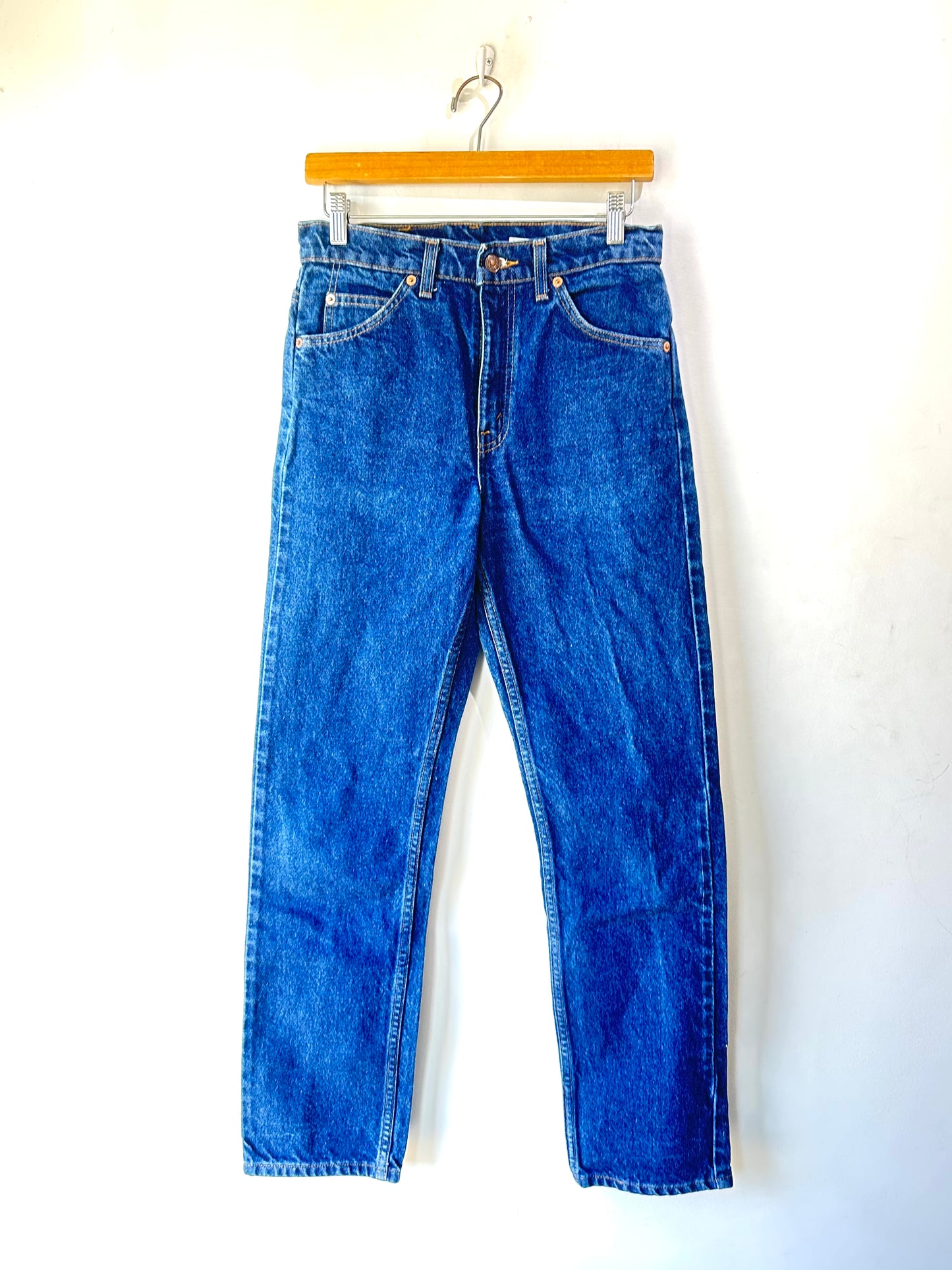 Blue jeans on a hanger against a white background