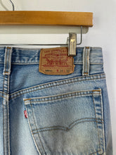 Close-up of Levi's jeans with a tag on a hanger against a white background
