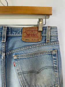 Close-up of Levi's jeans with a tag on a hanger against a white background