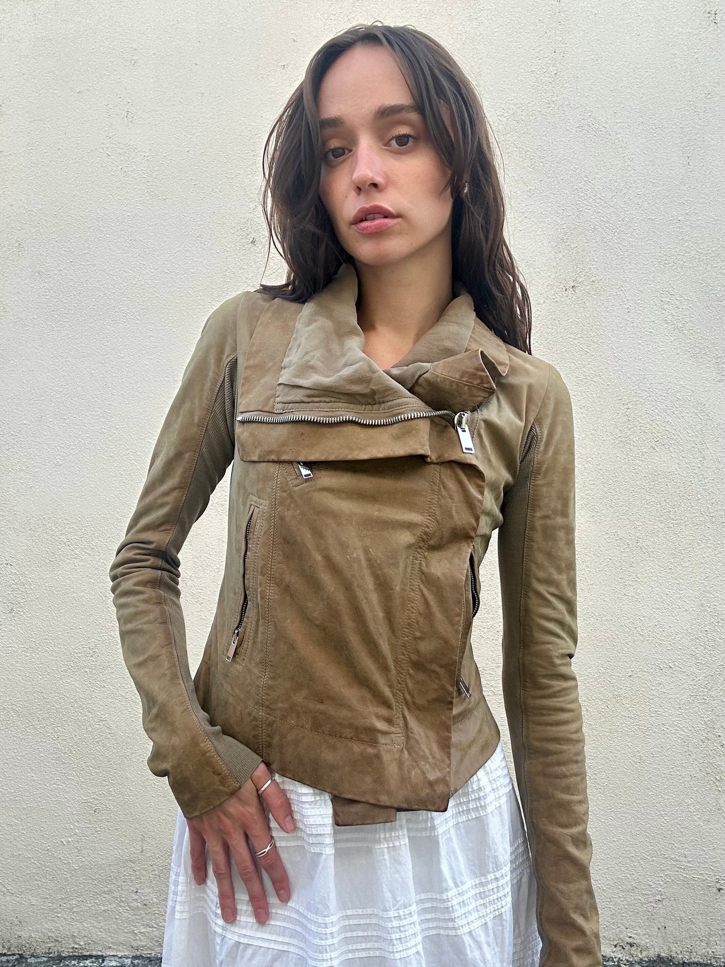 Woman wearing a brown jacket against a plain background